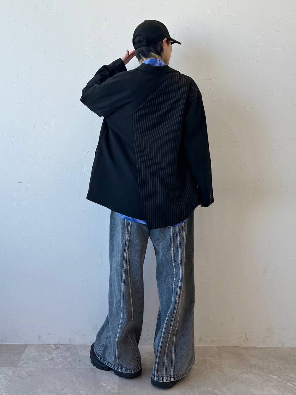 ブラック系のスニーカー、ブラック系のテーラードジャケット、ブラック系のデニムパンツを着用したレディースの春コーディネートの5枚目の写真