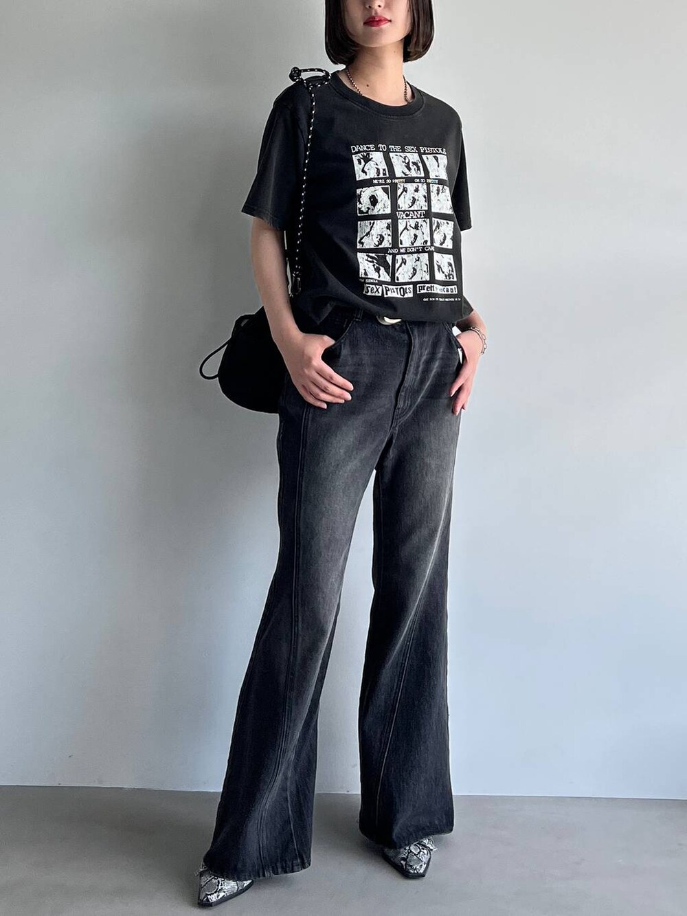 ブラック系のデニムパンツ、ホワイト系のパンプス、ブラック系のTシャツ/カットソーを着用したレディースの夏コーディネートの3枚目の写真