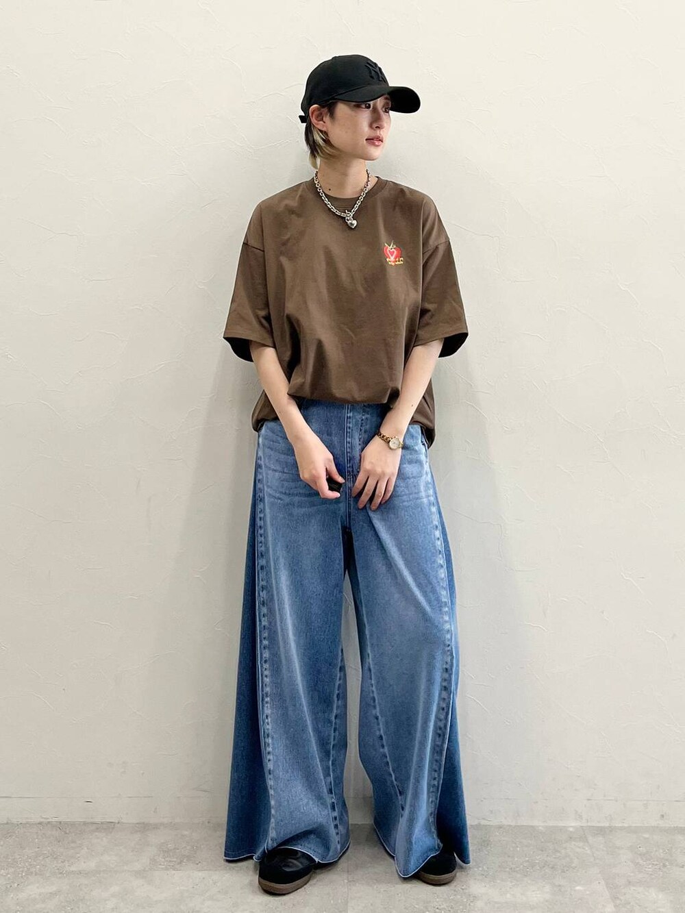 ブルー系のデニムパンツ、ブラック系のスニーカー、ブラウン系のTシャツ/カットソーを着用したレディースの春コーディネートの7枚目の写真