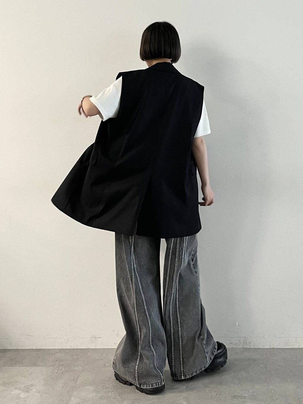 ブラック系のスニーカー、ブラック系のデニムパンツ、ブラック系のその他アウターを着用したレディースの春コーディネートの5枚目の写真