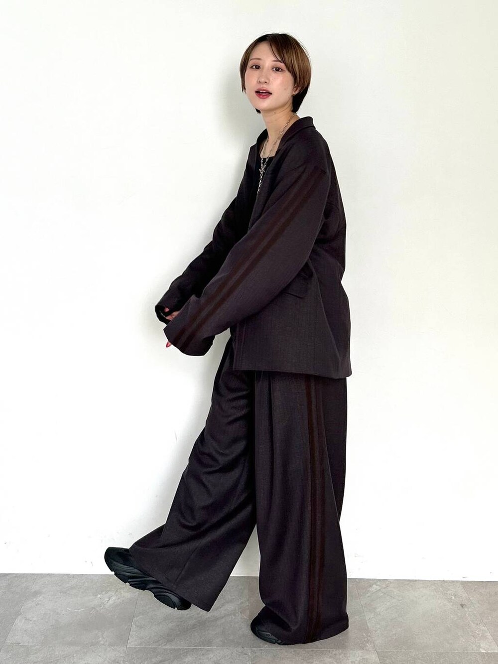 ブラウン系のスラックス、ブラウン系のテーラードジャケット、ブラック系のベルトを着用したレディースの秋コーディネートの3枚目の写真