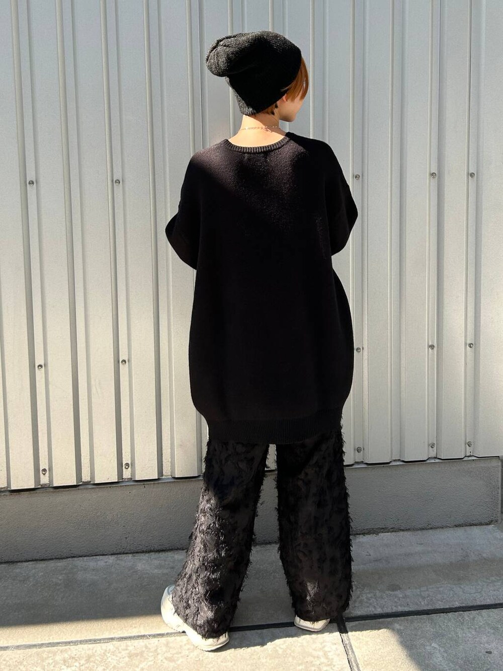 ブラック系のニット/セーター、ブラック系のスラックス、ブラック系のニットキャップ/ビーニーを着用したレディースの冬コーディネートの7枚目の写真