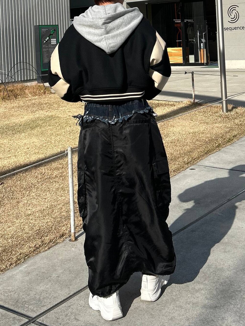 グレー系のパーカー、ベージュ系のスタジャン、ブラック系のスカートを着用したレディースの冬コーディネートの8枚目の写真
