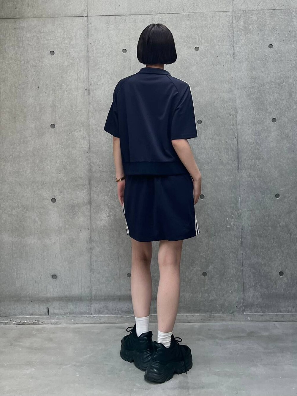 ブラック系のスニーカー、ブラック系のキャミソール、ブルー系のスカートを着用したレディースの夏コーディネートの6枚目の写真