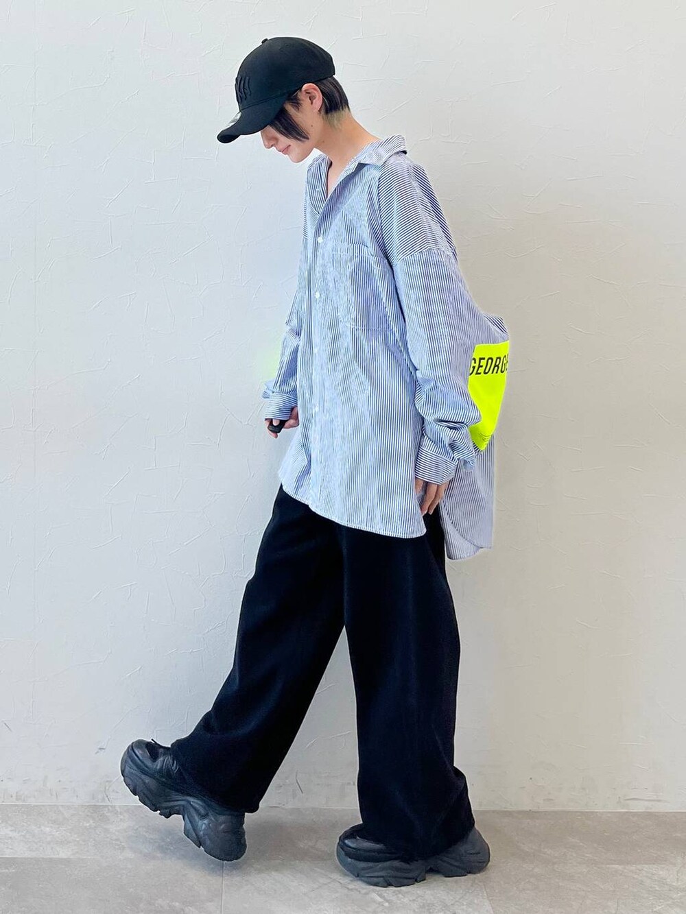 ブラック系のスニーカー、ブラック系のチノパンツ、ブラック系のキャップを着用したレディースの春コーディネートの3枚目の写真