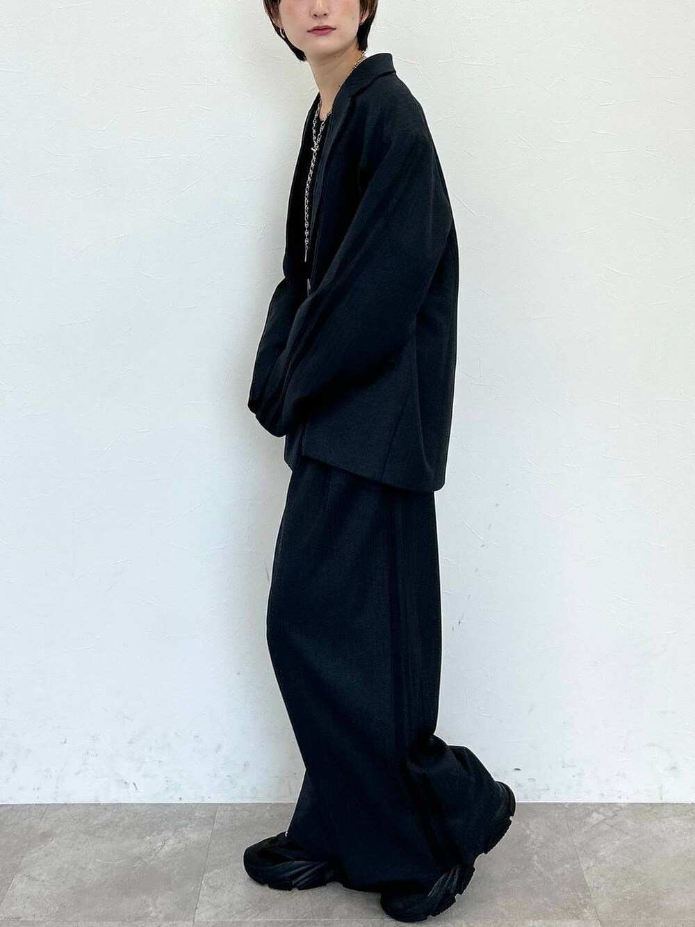 ブラック系のスラックス、ブラック系のテーラードジャケット、ブラック系のベルトを着用したレディースの秋コーディネートの4枚目の写真