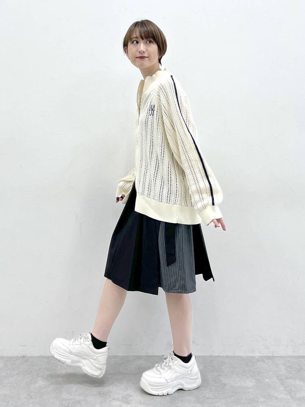 ブラック系のスラックス、ホワイト系のカーディガン/ボレロ、シルバー系のネックレスを着用したレディースの冬コーディネートの3枚目の写真