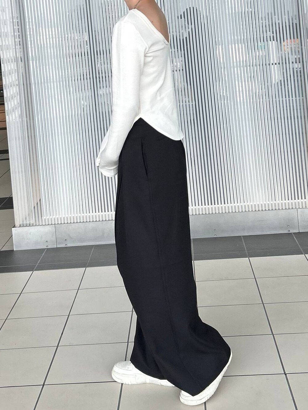 ホワイト系のTシャツ/カットソー、ブラック系のスラックス、シルバー系のネックレスを着用したレディースの春コーディネートの5枚目の写真