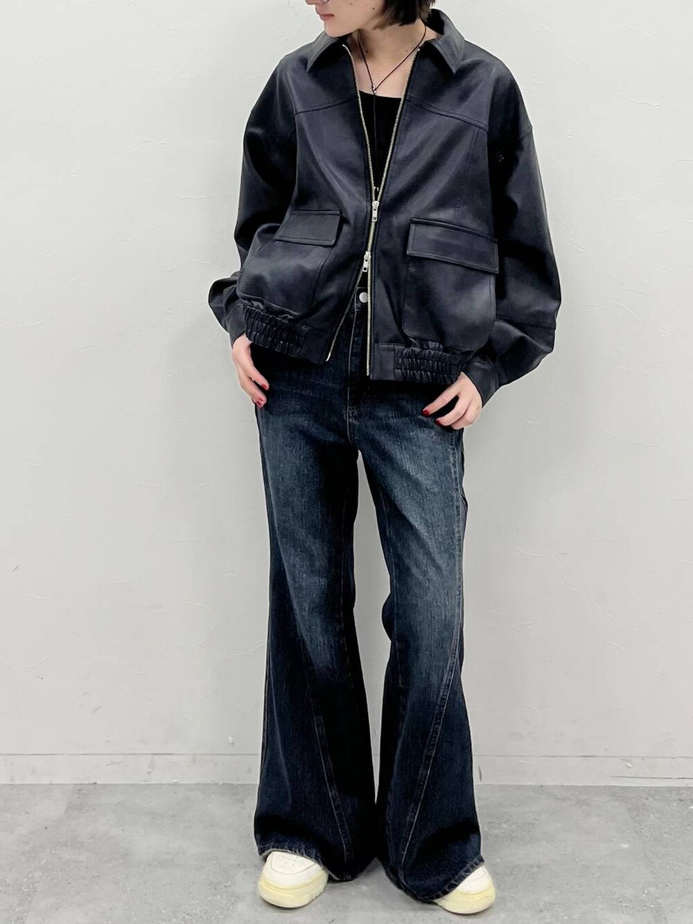 ブルー系のデニムパンツ、ブラック系のブルゾン、ブラック系のTシャツ/カットソーを着用したレディースの夏コーディネートの2枚目の写真