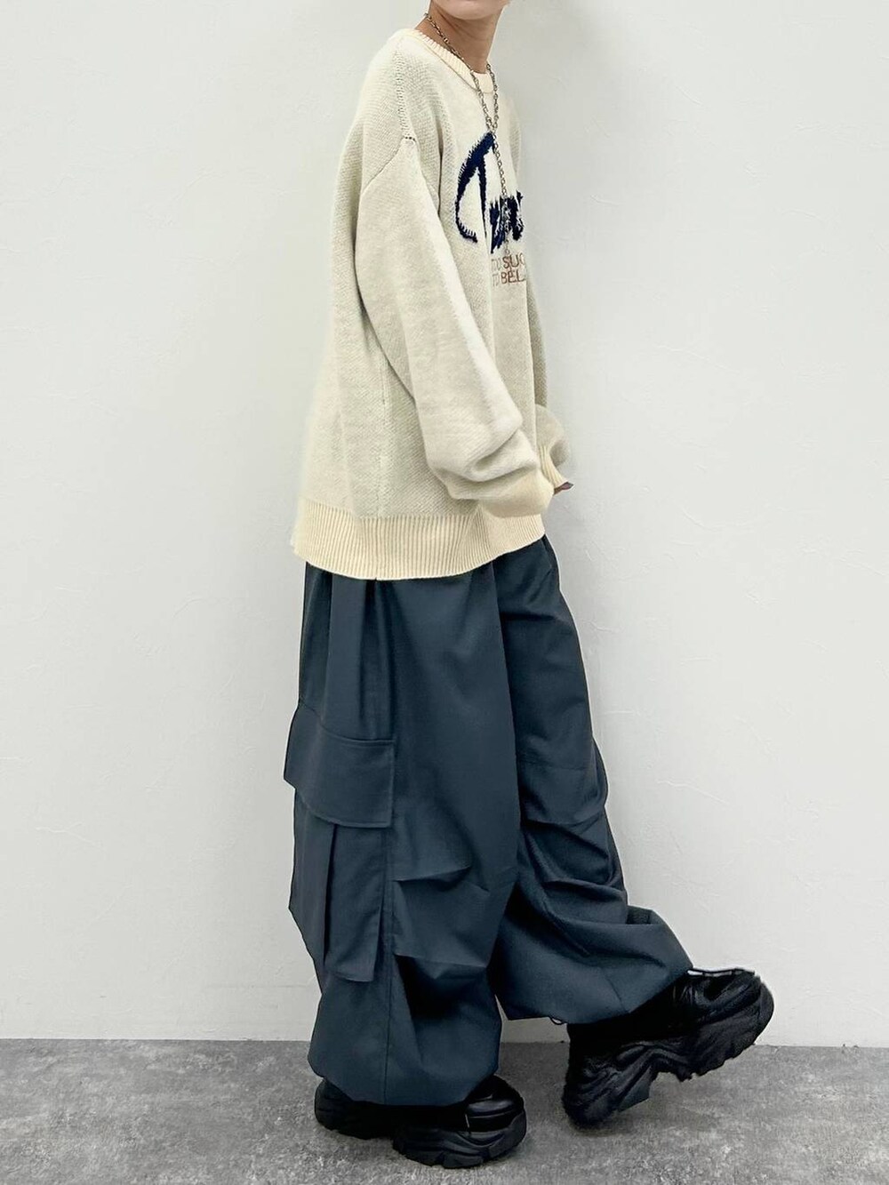 ブラック系のスニーカー、ホワイト系のニット/セーター、グレー系のカーゴパンツを着用したレディースの冬コーディネートの5枚目の写真