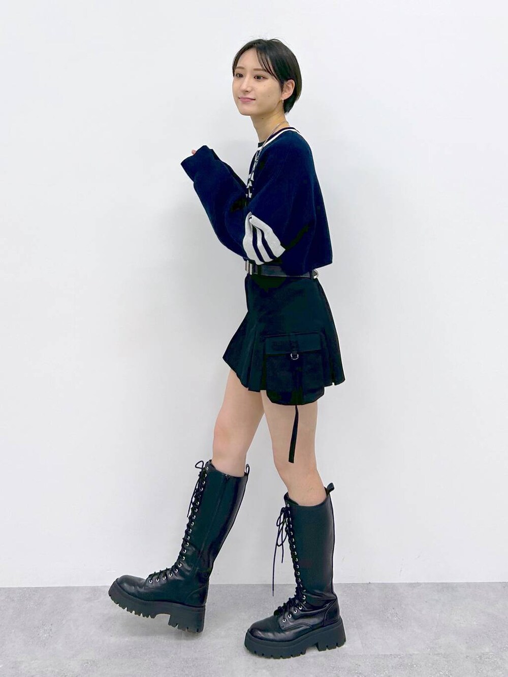 ブラック系のブーツ、ブラック系のスカート、ブルー系のニット/セーターを着用したレディースの冬コーディネートの3枚目の写真