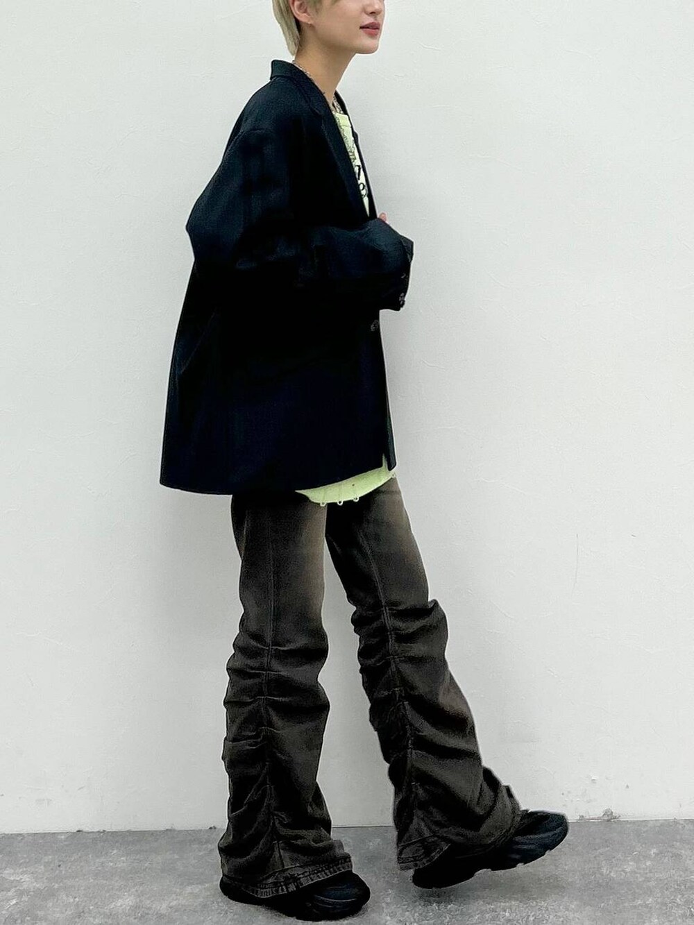 ブラック系のデニムパンツ、ブラック系のテーラードジャケット、グリーン系のニット/セーターを着用したレディースの秋コーディネートの9枚目の写真