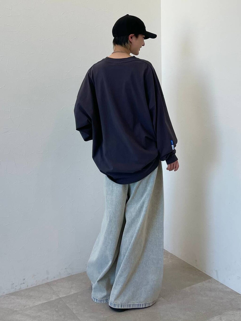 ブラック系のスニーカー、ブルー系のデニムパンツ、ブラック系のキャップを着用したレディースの春コーディネートの7枚目の写真