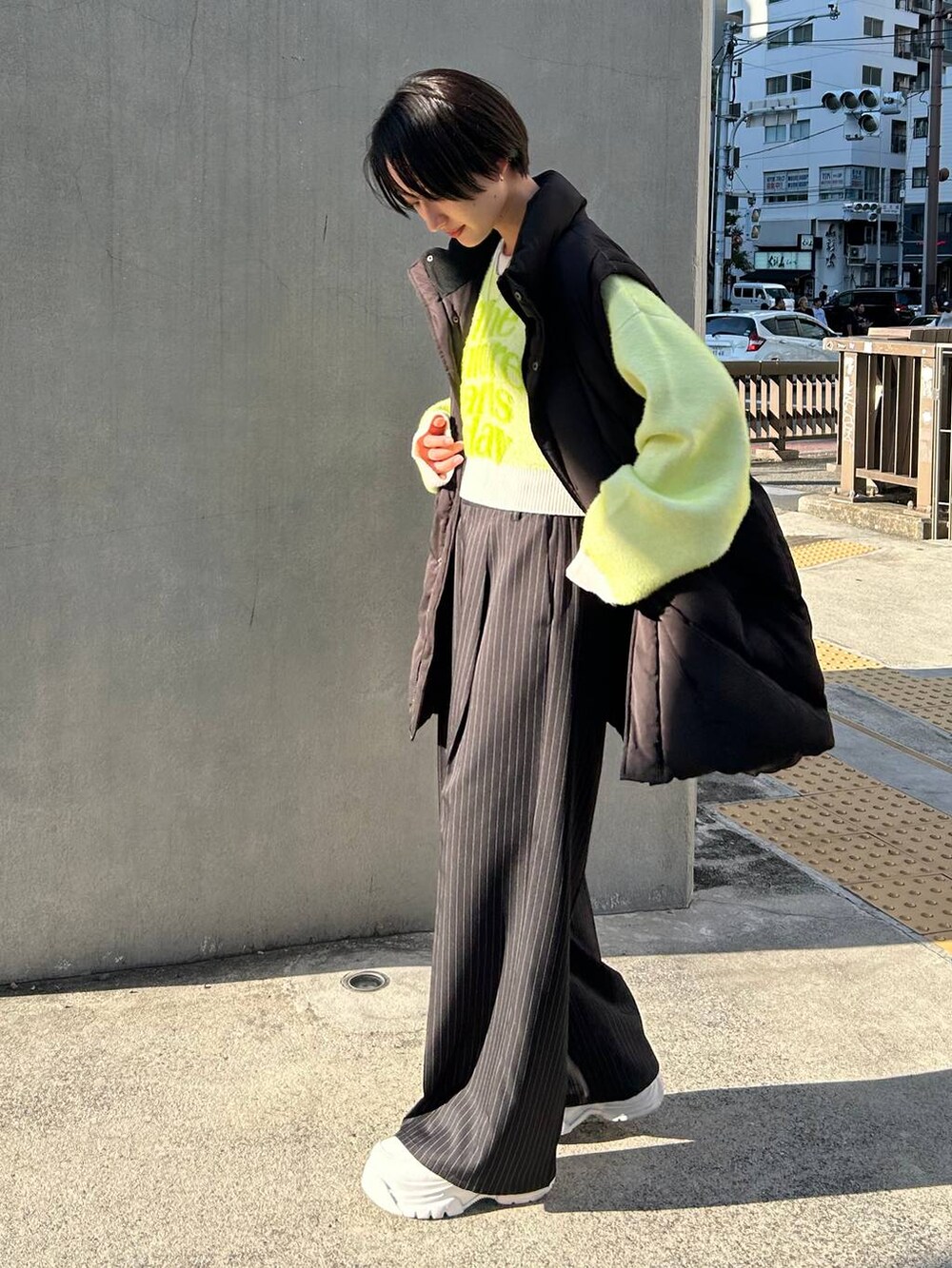 ブラック系のスラックス、ホワイト系のニット/セーター、ブラック系のブルゾンを着用したレディースの冬コーディネートの4枚目の写真