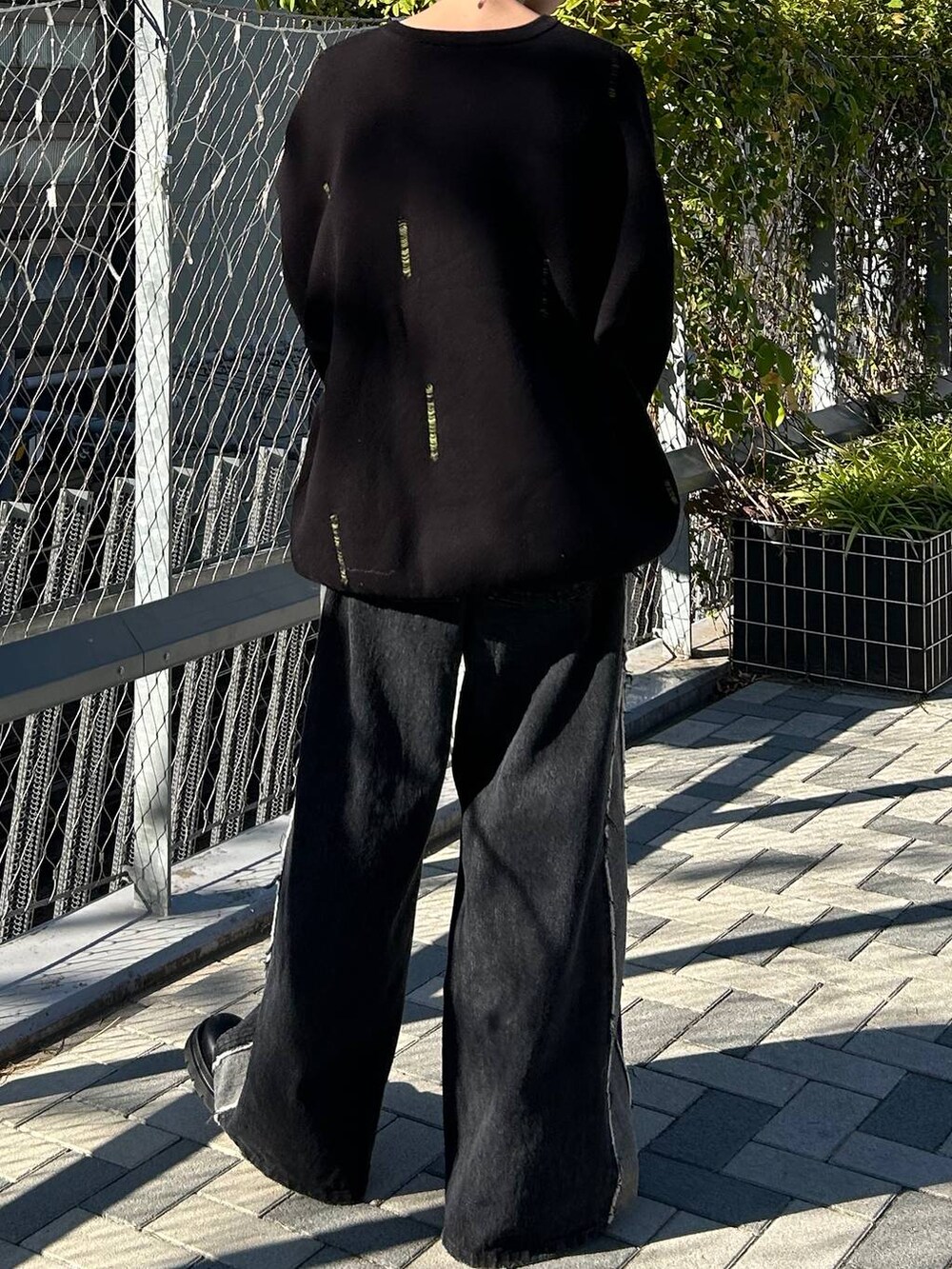 ブラック系のニット/セーターを着用したレディースの秋コーディネートの8枚目の写真