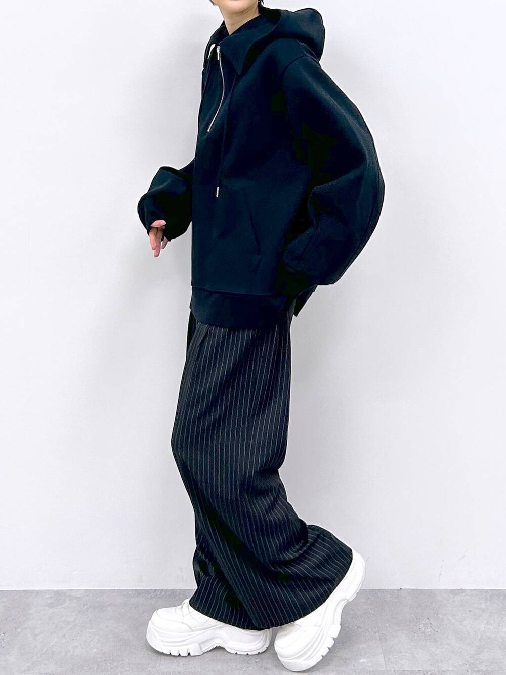 ブラック系のスラックス、ブラック系のパーカーを着用したレディースの秋コーディネートの4枚目の写真