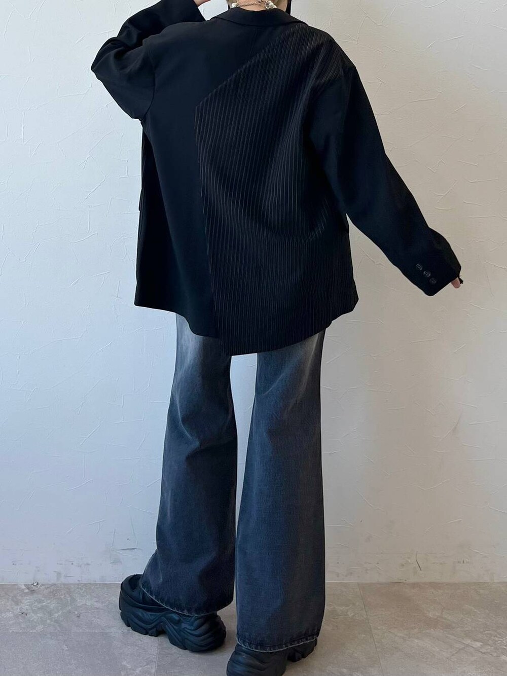 ブラック系のスニーカー、ブラック系のキャミソール、ブラック系のテーラードジャケットを着用したレディースの春コーディネートの8枚目の写真