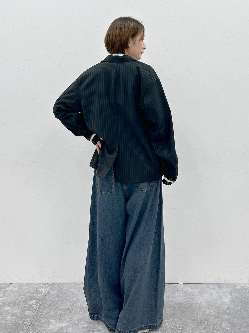 ブルー系のデニムパンツ、ホワイト系のTシャツ/カットソー、ブラック系のテーラードジャケットを着用したレディースの春コーディネートの7枚目の写真