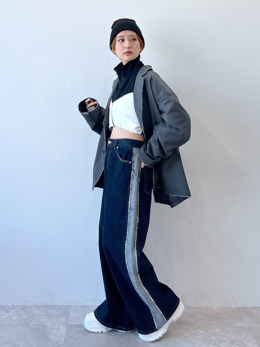 ブルー系のデニムパンツ、グレー系のテーラードジャケット、ブラック系のナイロンジャケットを着用したレディースの秋コーディネートの5枚目の写真