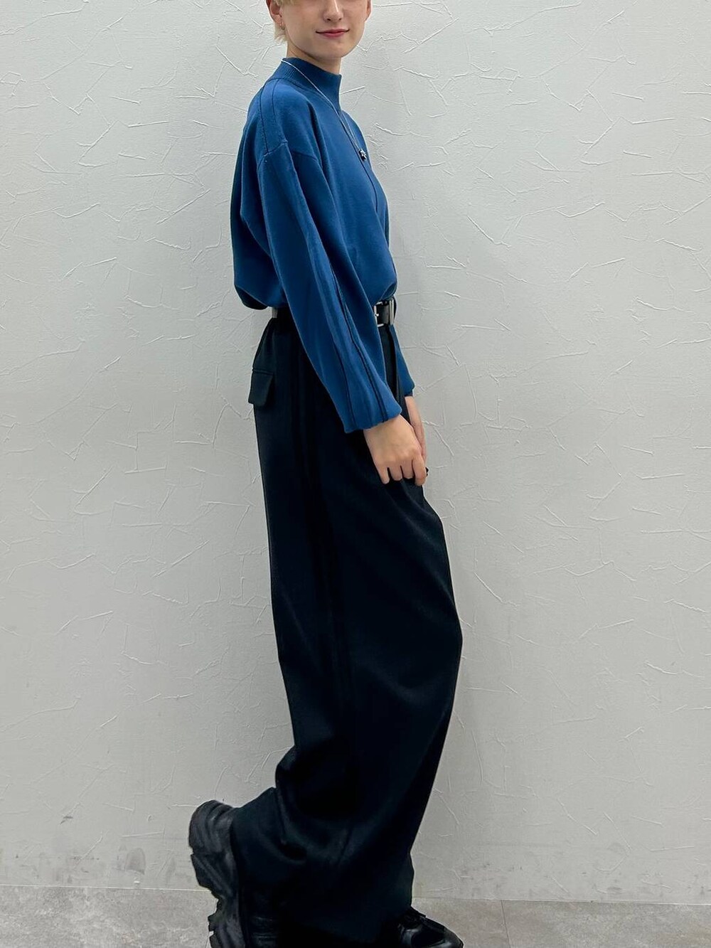 ブラック系のスニーカー、ブルー系のニット/セーター、ブラック系のスラックスを着用したレディースの秋コーディネートの5枚目の写真