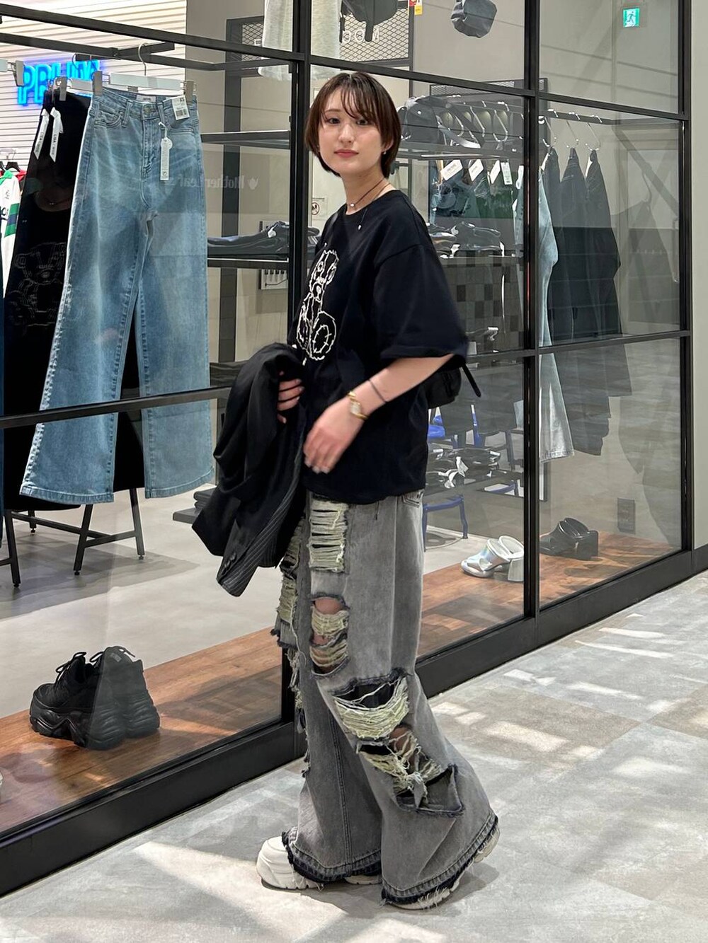 ブラック系のショルダーバッグ、ブラック系のテーラードジャケット、ブラック系のデニムパンツを着用したレディースの春コーディネートの4枚目の写真