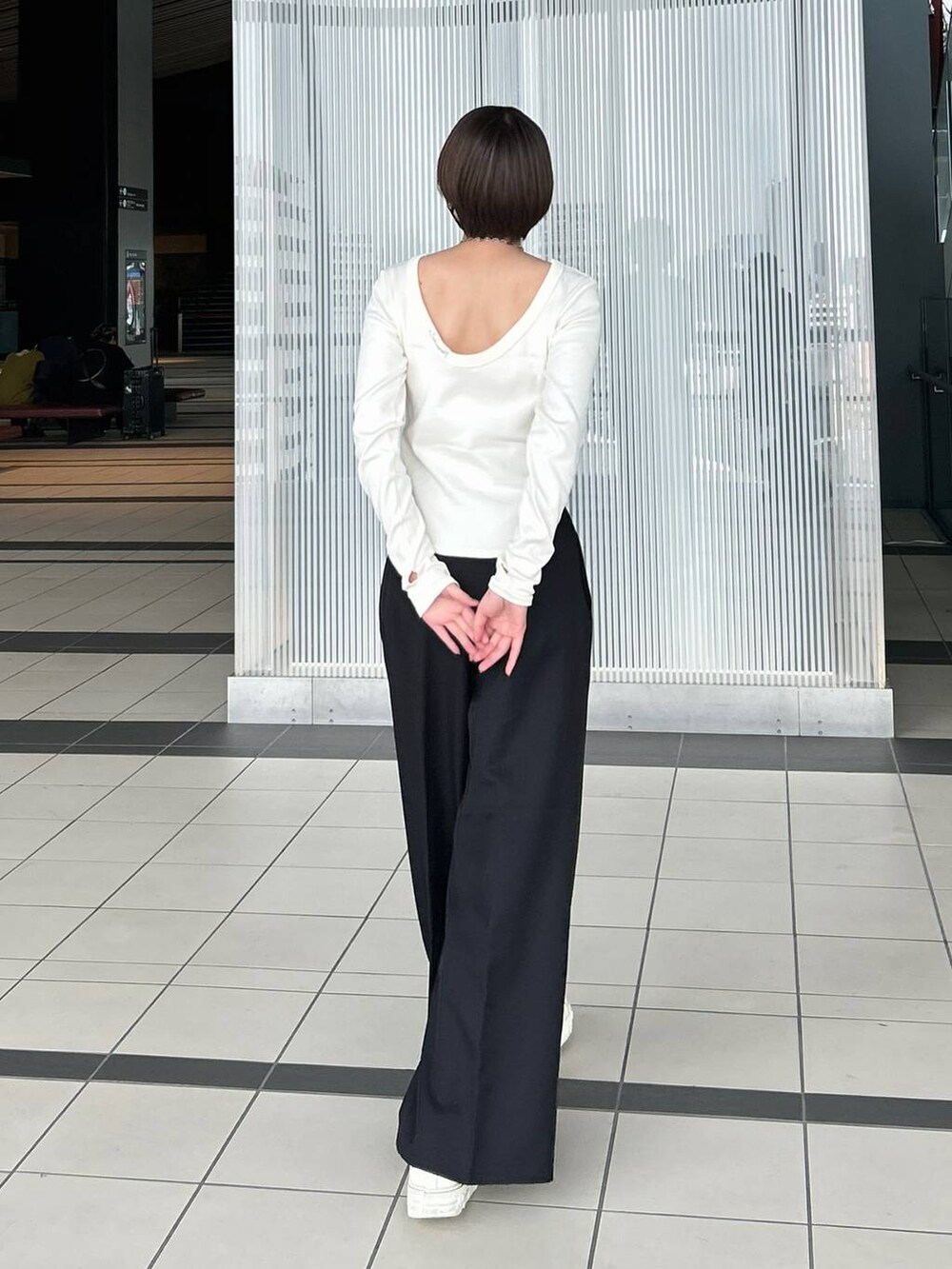 ホワイト系のTシャツ/カットソー、ブラック系のスラックス、シルバー系のネックレスを着用したレディースの春コーディネートの6枚目の写真