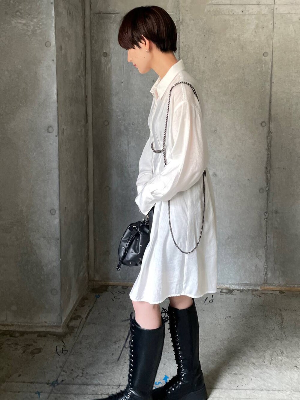 ブラック系のブーツ、ブラック系のショルダーバッグ、ホワイト系のシャツ/ブラウスを着用したレディースの秋コーディネートの2枚目の写真