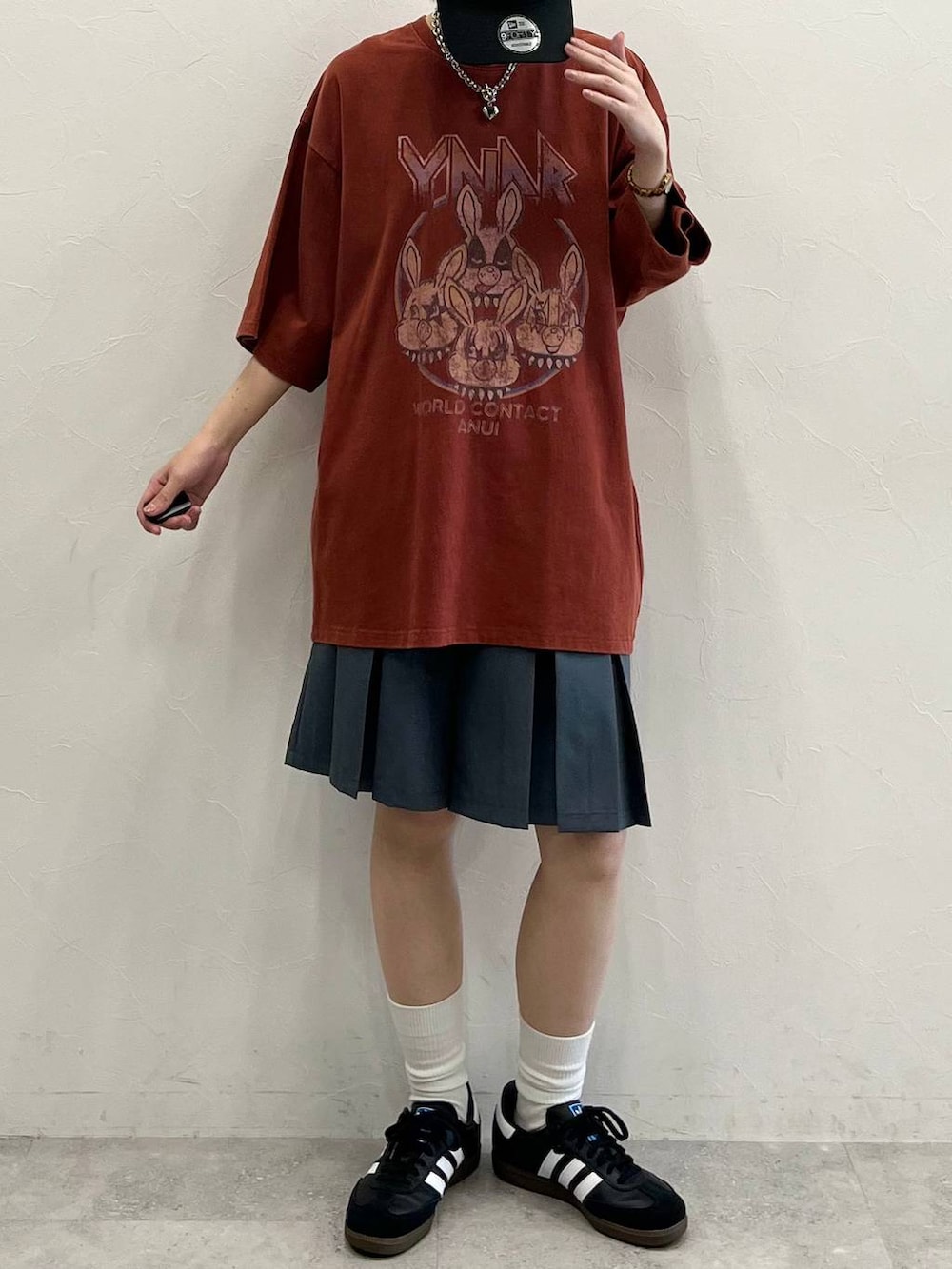 グレー系のその他パンツ、ブラック系のスニーカー、レッド系のTシャツ/カットソーを着用したレディースの春コーディネートの2枚目の写真