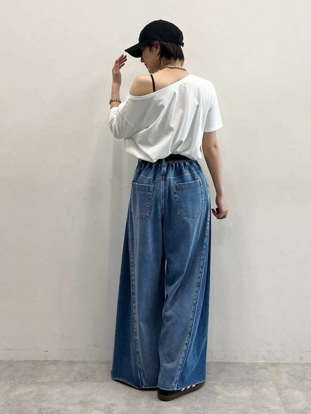 ブラック系のキャミソール、ブラック系のスニーカー、ブルー系のデニムパンツを着用したレディースの春コーディネートの5枚目の写真