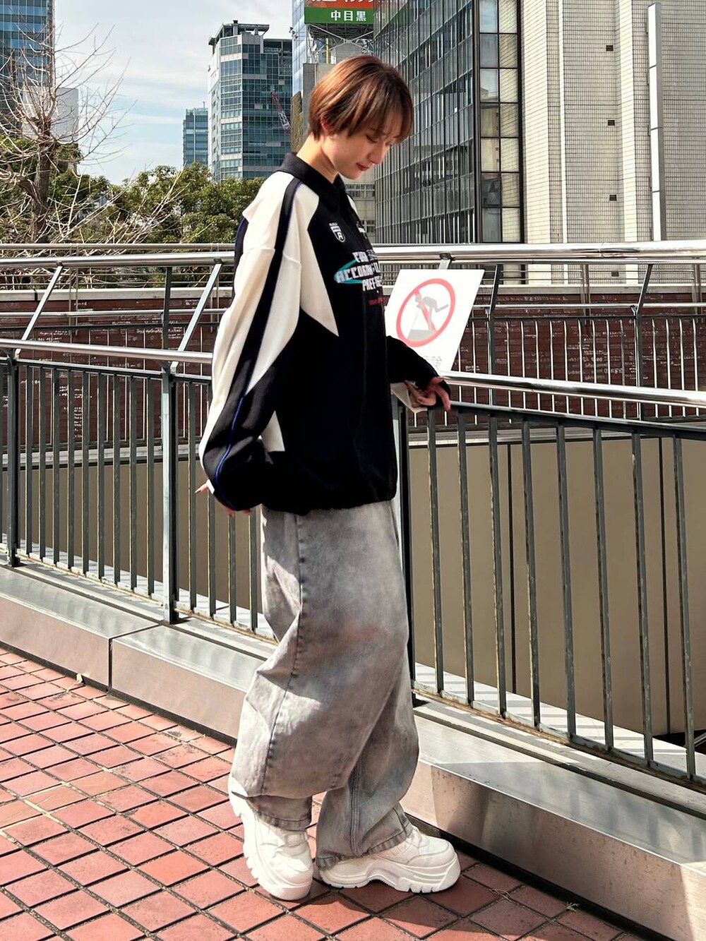 ブラック系のポロシャツ、ブラック系のデニムパンツを着用したレディースの春コーディネートの5枚目の写真