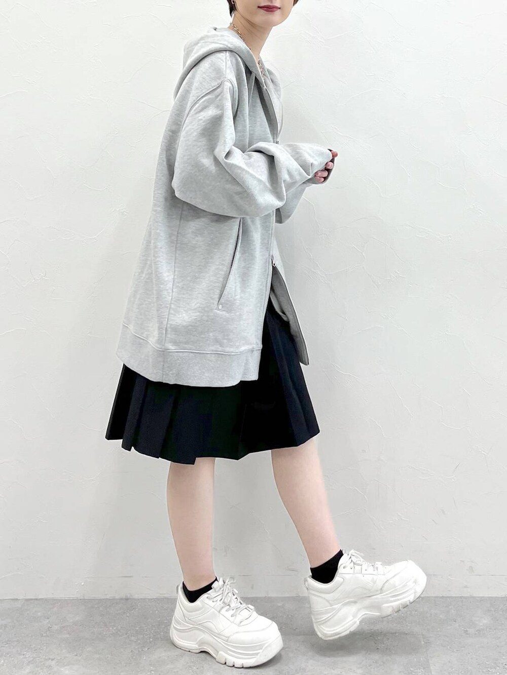 グレー系のパーカー、ブラック系のスラックスを着用したレディースの春コーディネートの6枚目の写真