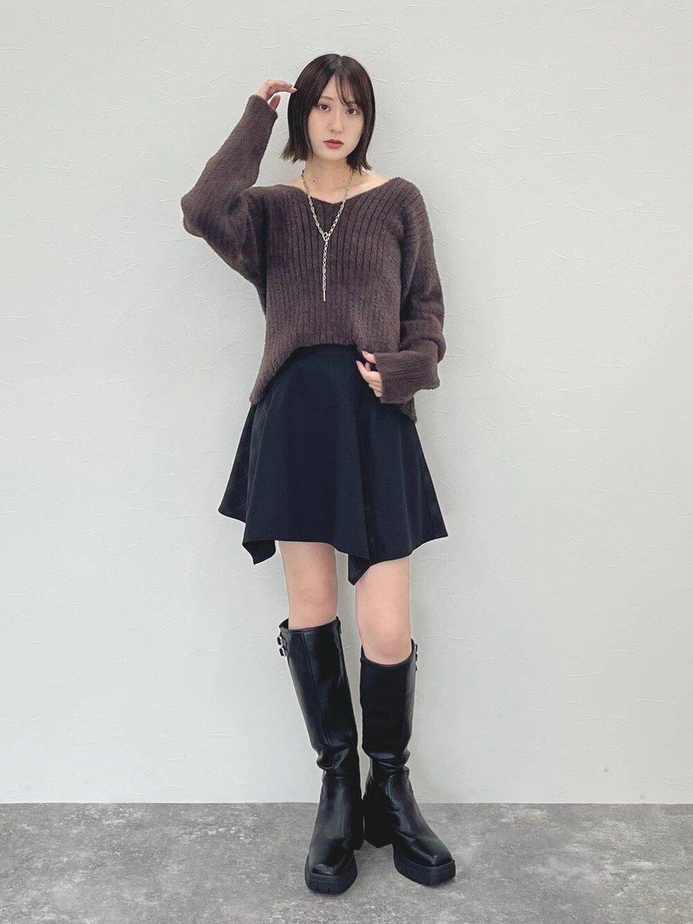 ブラック系のスカート、ブラウン系のニット/セーターを着用したレディースの秋コーディネートの2枚目の写真