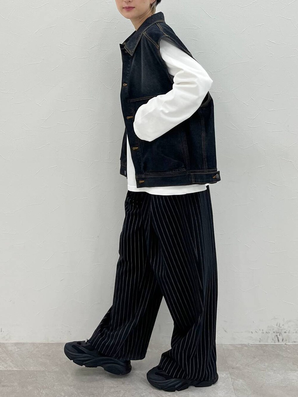 ホワイト系のTシャツ/カットソー、ブラック系のスラックス、ブラック系のデニムジャケットを着用したレディースの春コーディネートの4枚目の写真