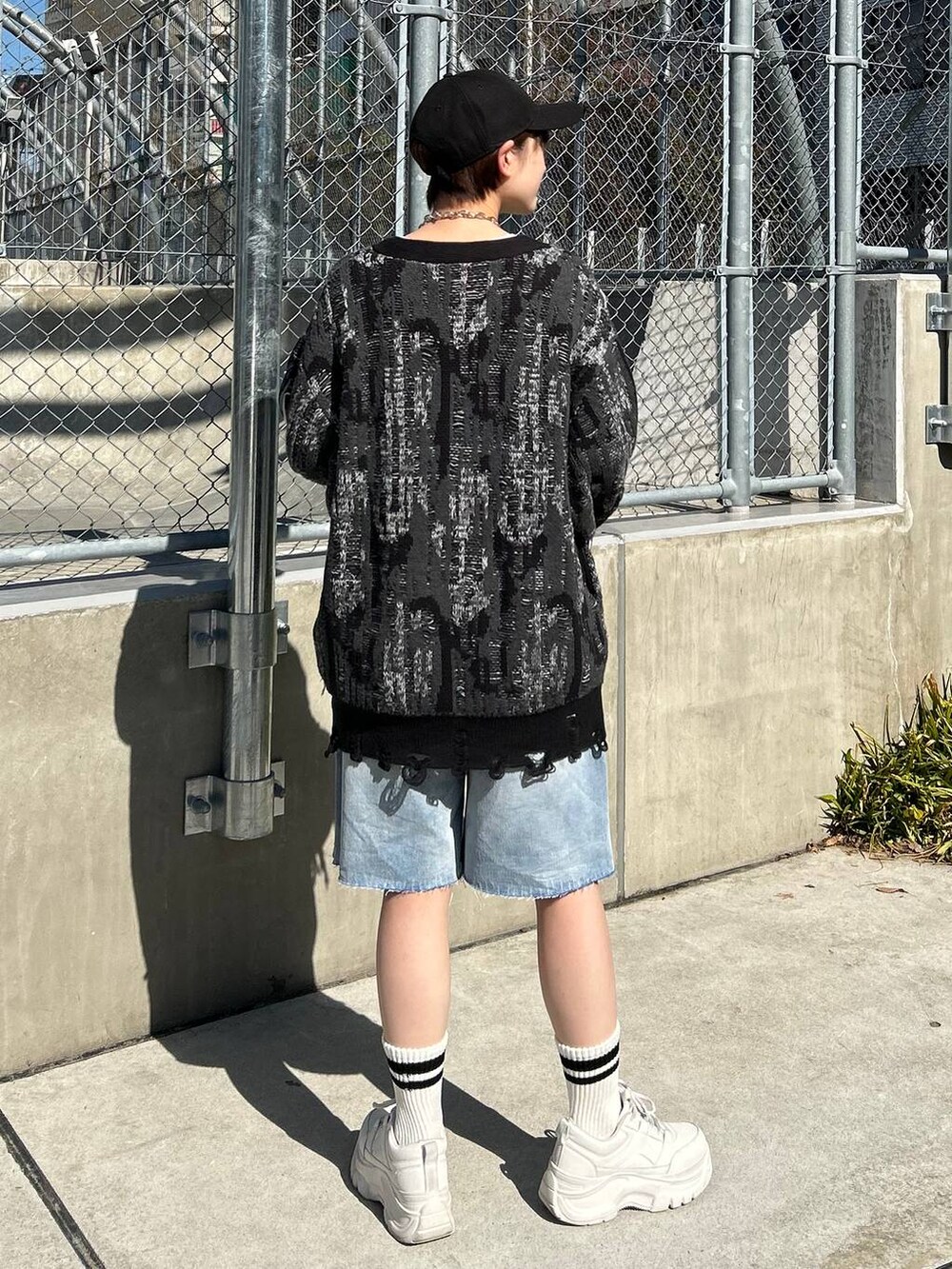 ホワイト系のTシャツ/カットソー、ブラック系のカーディガン/ボレロ、ブルー系のデニムパンツを着用したレディースの春コーディネートの6枚目の写真