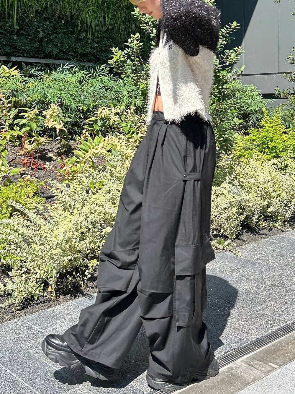 ブラック系のショルダーバッグ、ブラック系のスニーカー、ホワイト系のニット/セーターを着用したレディースの秋コーディネートの4枚目の写真