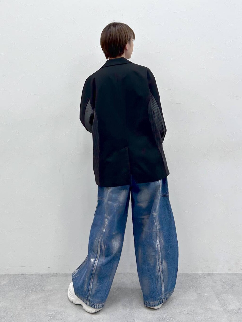 ブラック系のテーラードジャケット、ブルー系のデニムパンツ、シルバー系のネックレスを着用したレディースの春コーディネートの5枚目の写真