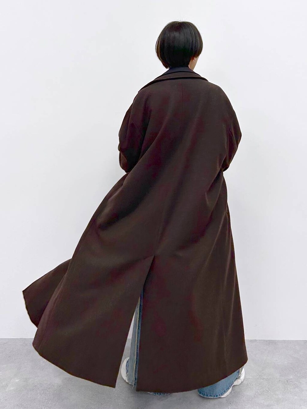 イエロー系のニット/セーター、ブルー系のデニムパンツ、ブラウン系のその他アウターを着用したレディースの秋コーディネートの6枚目の写真