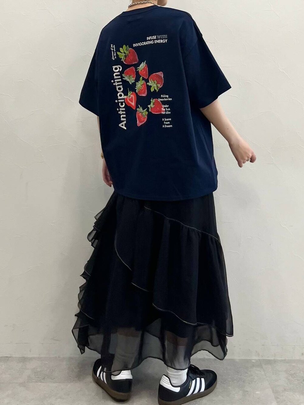 ブラック系のスカート、ブラック系のスニーカー、ブルー系のTシャツ/カットソーを着用したレディースの春コーディネートの2枚目の写真