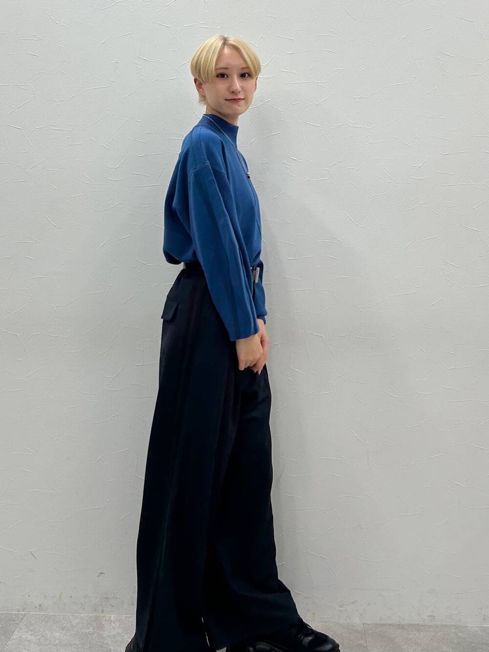 ブラック系のスニーカー、ブルー系のニット/セーター、ブラック系のスラックスを着用したレディースの秋コーディネートの4枚目の写真