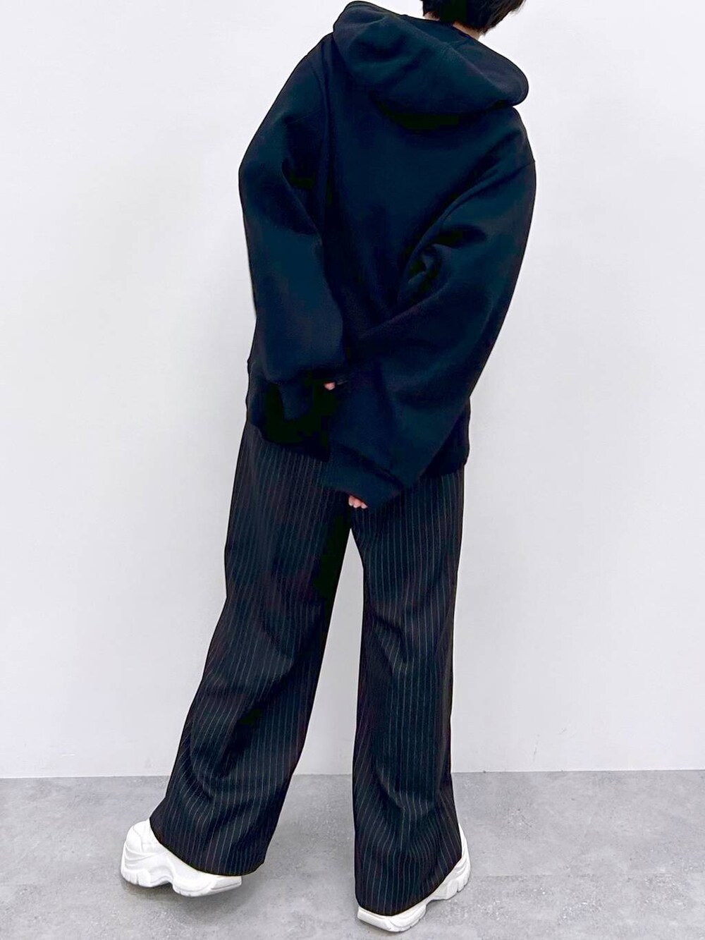 ブラック系のスラックス、ブラック系のパーカーを着用したレディースの秋コーディネートの7枚目の写真