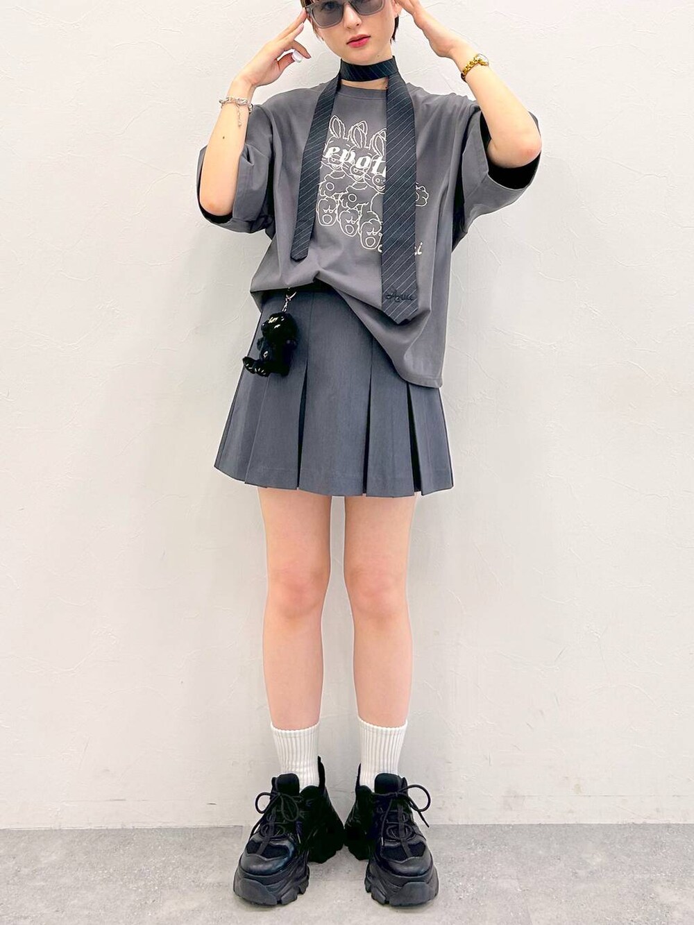 ブラック系のスニーカー、グレー系のTシャツ/カットソー、グレー系のネクタイを着用したレディースの夏コーディネートの6枚目の写真