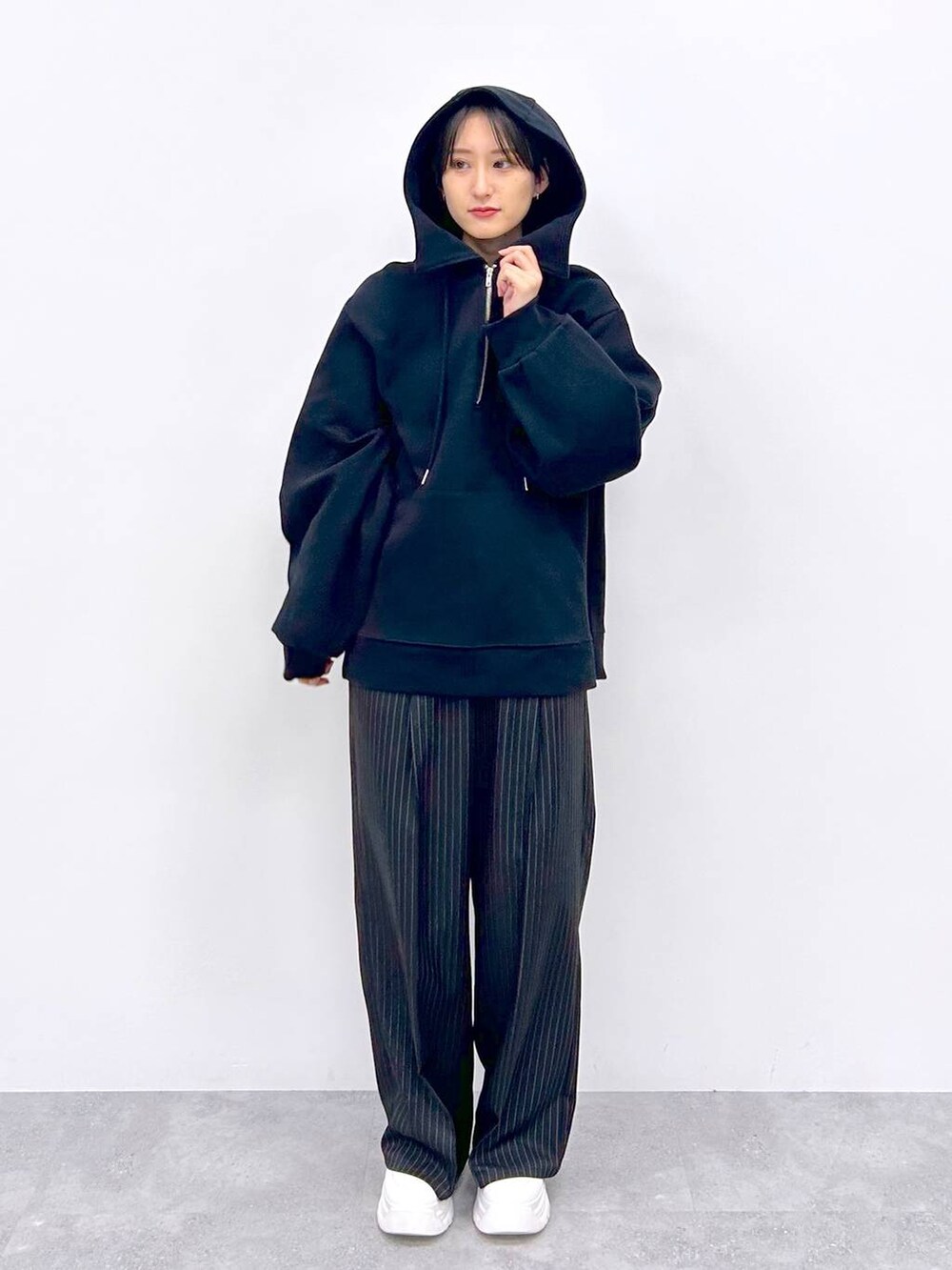 ブラック系のスラックス、ブラック系のパーカーを着用したレディースの秋コーディネートの3枚目の写真