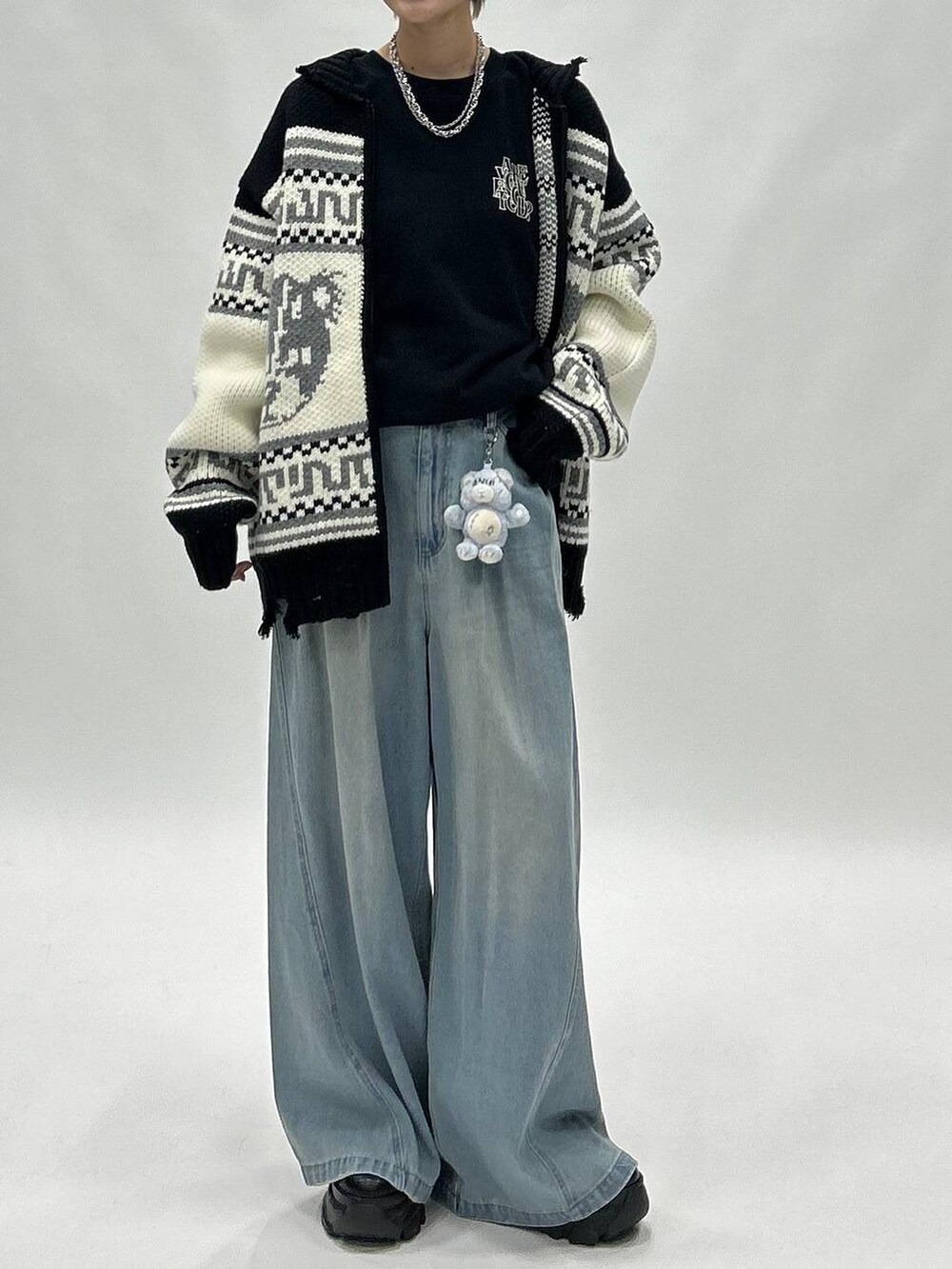 ブルー系のデニムパンツ、ブラック系のブーツ、ブラック系のスウェットを着用したレディースの秋コーディネートの2枚目の写真