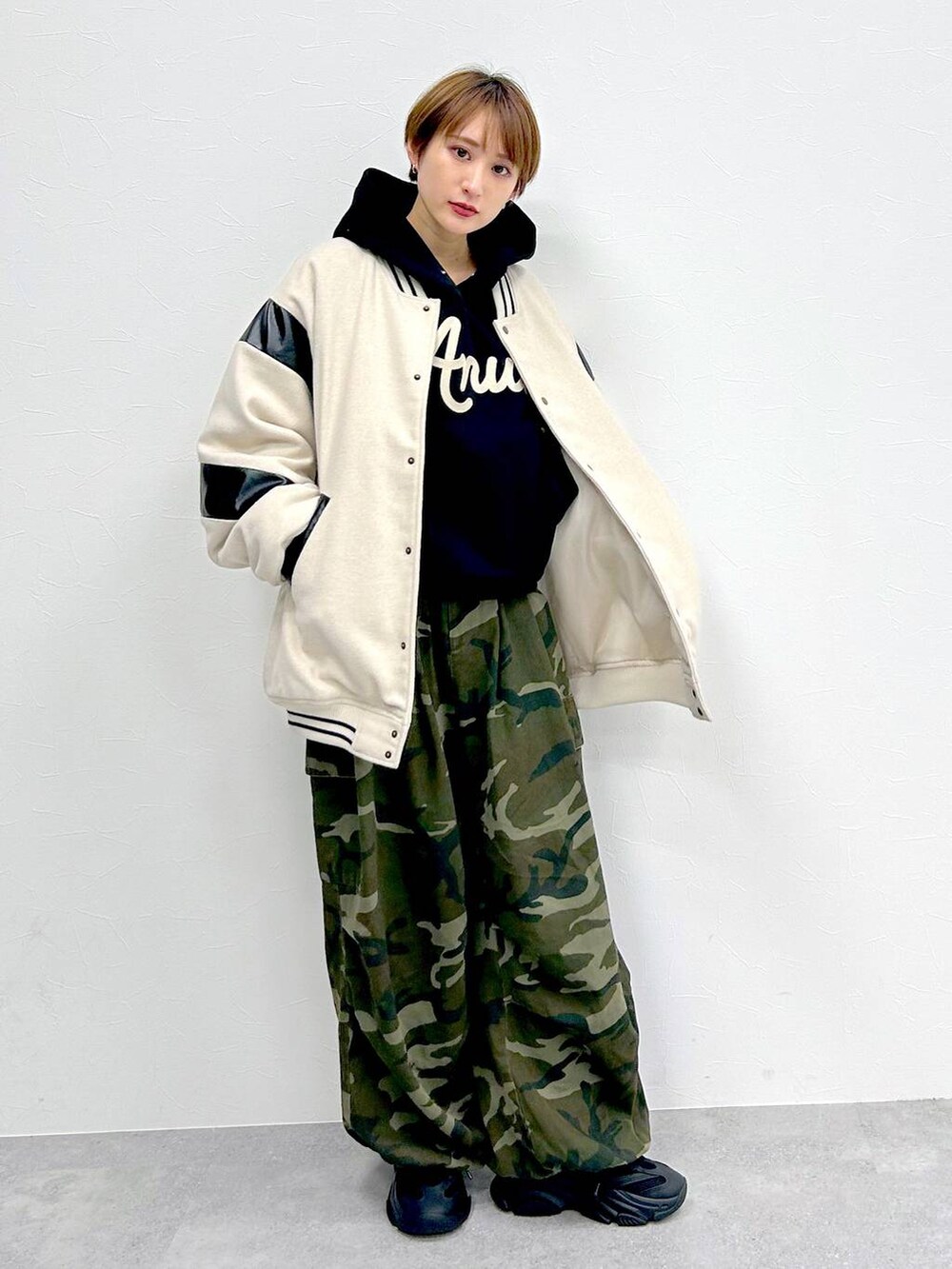 ブラック系のパーカー、グリーン系のその他パンツ、ベージュ系のスタジャンを着用したレディースの冬コーディネートの5枚目の写真