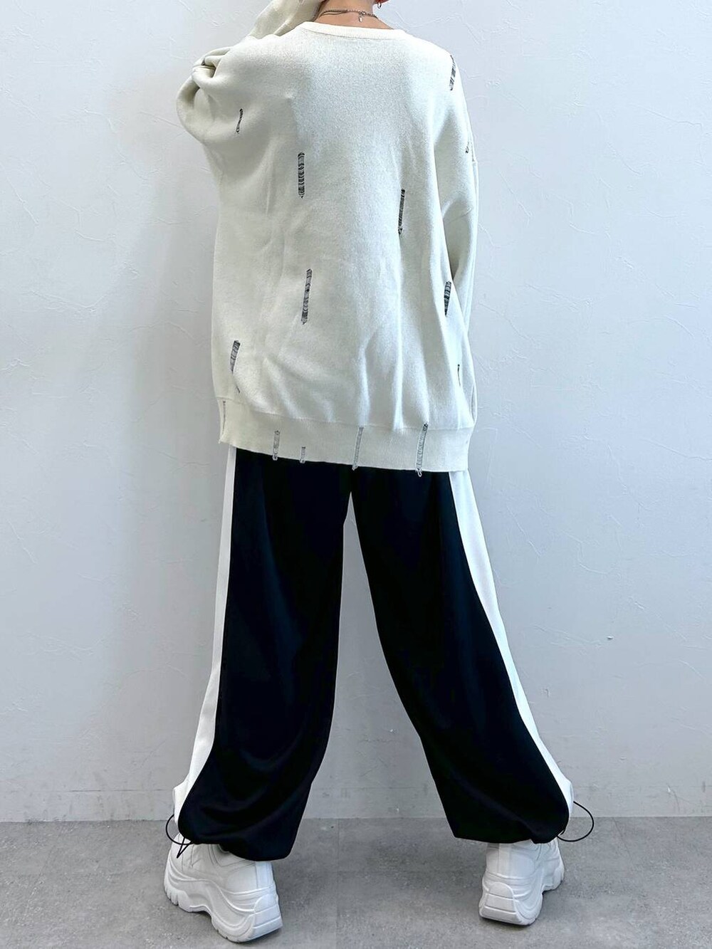 ブラック系のその他パンツ、ホワイト系のニット/セーターを着用したレディースの秋コーディネートの7枚目の写真