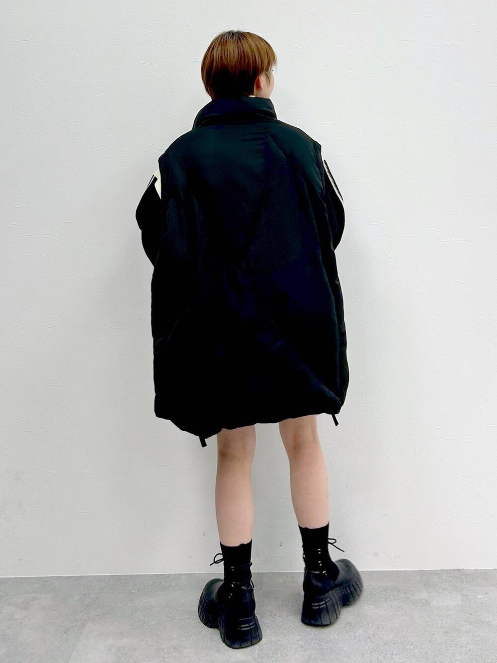 ブラック系のブルゾン、ブラック系のブーツ、ブラック系のスカートを着用したレディースの冬コーディネートの5枚目の写真