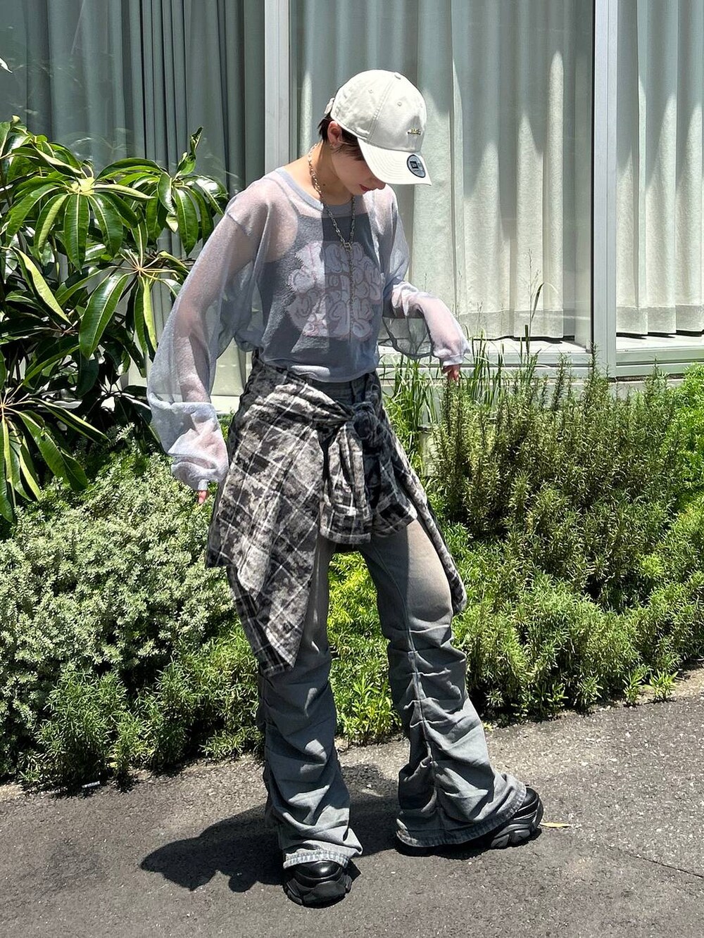 ブラック系のスニーカー、ブルー系のデニムパンツ、ブルー系のニット/セーターを着用したレディースの秋コーディネートの2枚目の写真