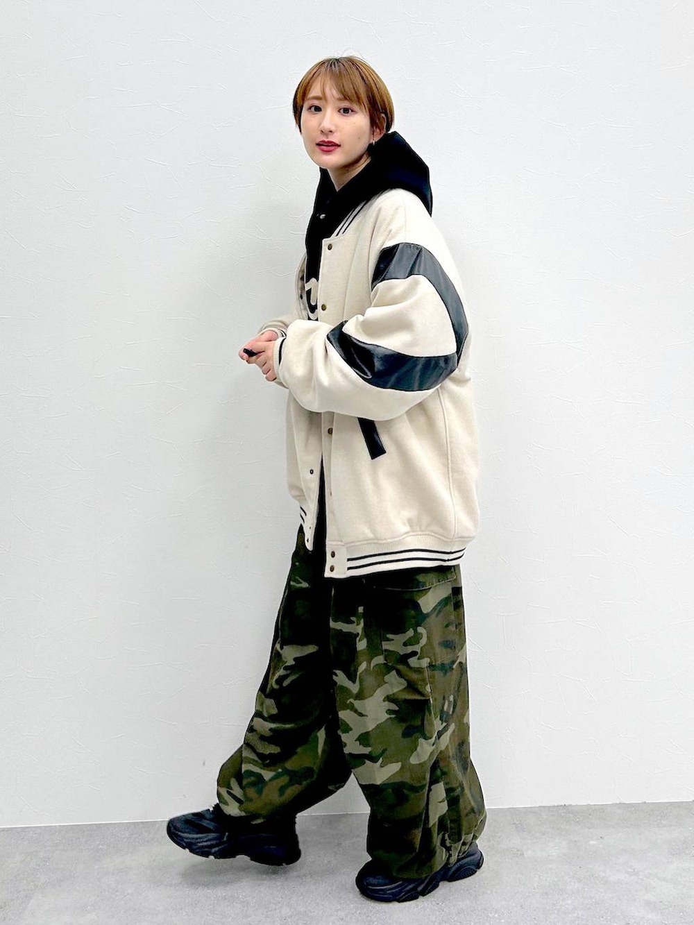 ブラック系のパーカー、グリーン系のその他パンツ、ベージュ系のスタジャンを着用したレディースの冬コーディネートの3枚目の写真