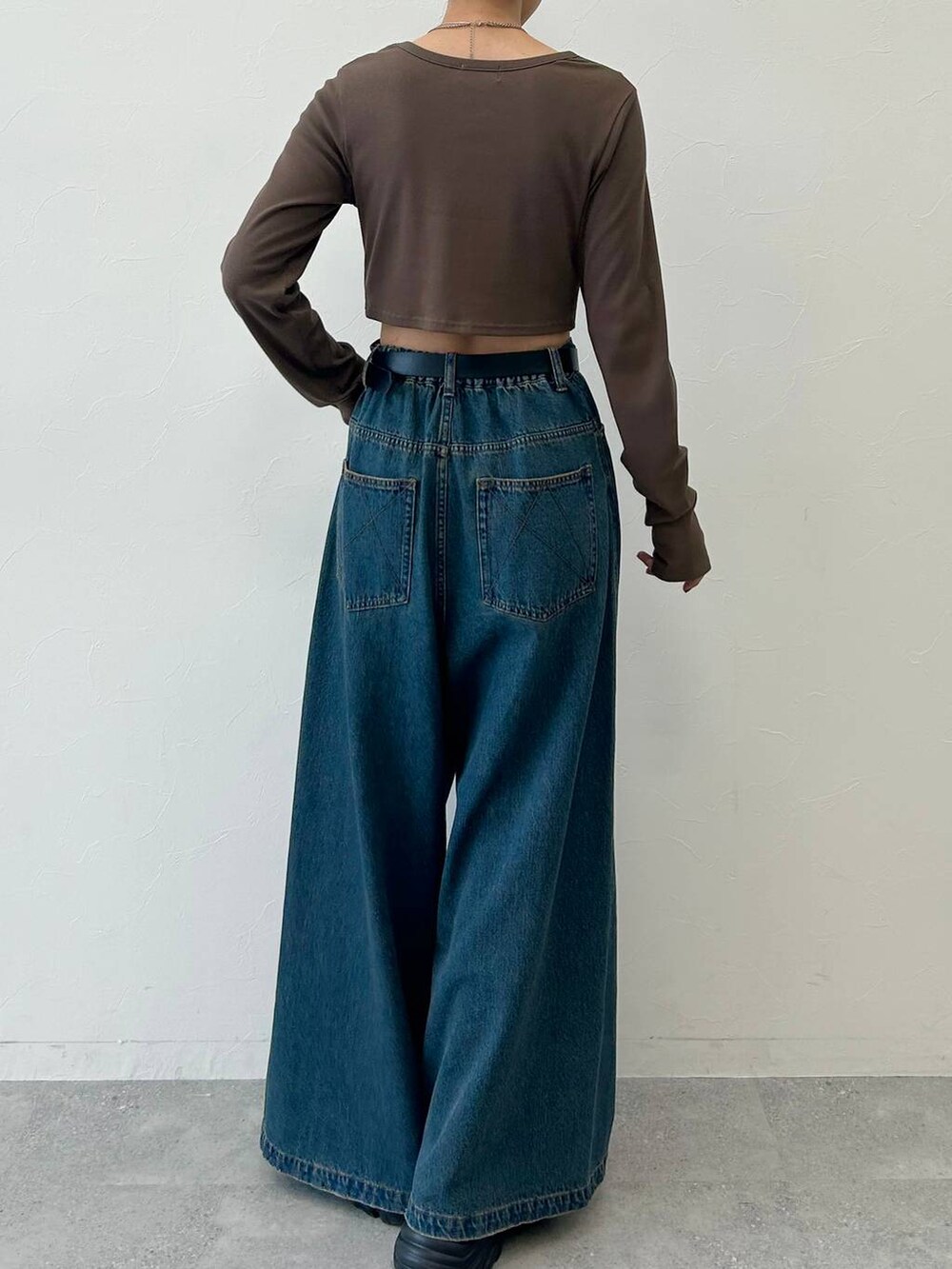 ブルー系のデニムパンツ、ブラック系のブーツ、ブラウン系のTシャツ/カットソーを着用したレディースの冬コーディネートの6枚目の写真