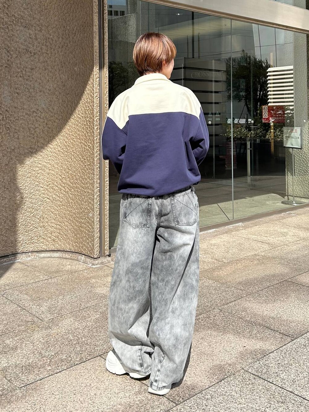 ブルー系のスウェット、ブラック系のデニムパンツを着用したレディースの春コーディネートの6枚目の写真